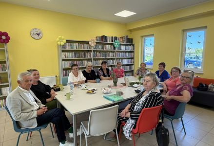 Uczestnicy spotkania zgromadzeni wokół stołu, na stole leżą zioła.
